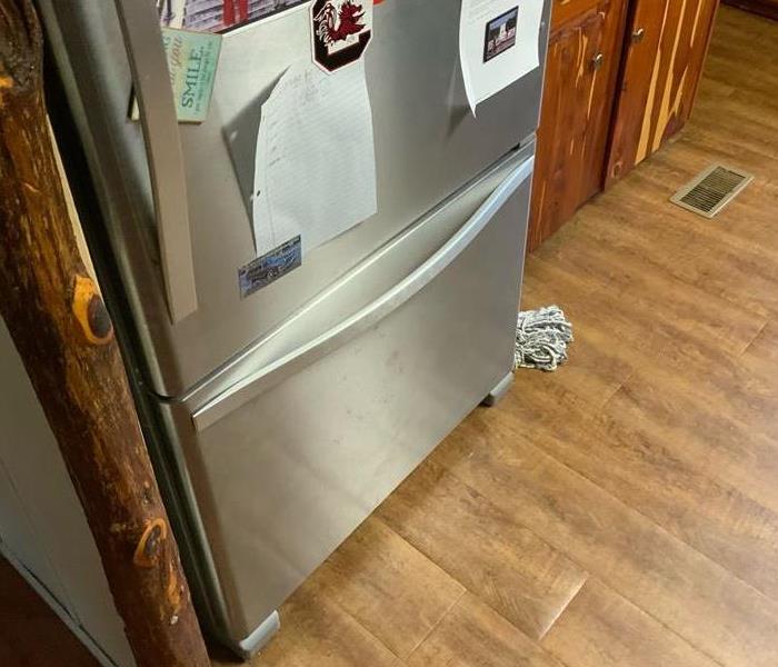 Flooring under fridge with water damage