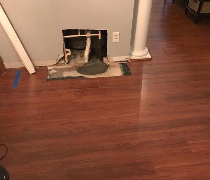 Living room that suffered from water damage by burst pipe in wall