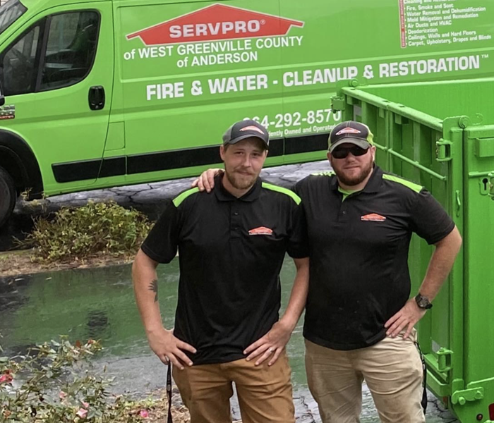 Production crew members standing outside office in front of SERVPRO green vans ready to go help at storm