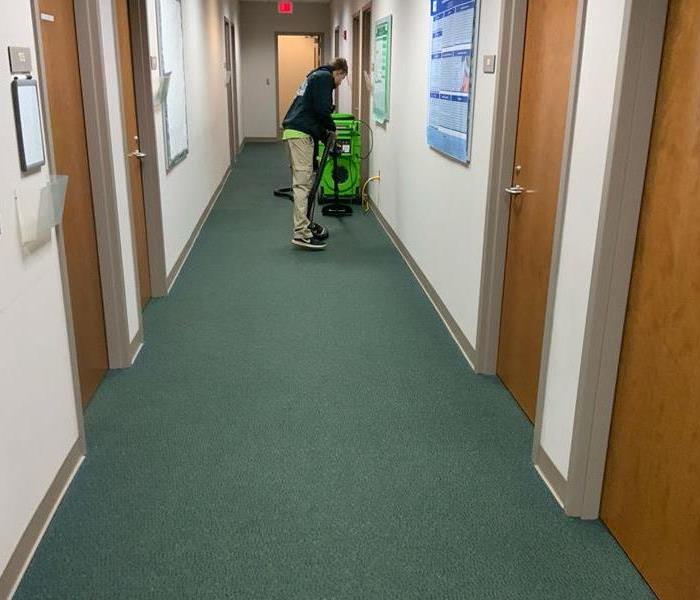 a production member providing general cleaning services in a hallway 